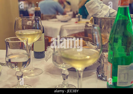 Tischdekoration nach einem Abendessen in einem italienischen Restaurant mit Wein, Flasche, Wasser und Brot Stockfoto