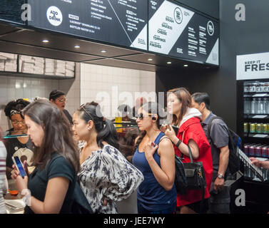 Kunden sehen ihre Pizzabestellung im Fließband Mode auf Eröffnung Tag der & Pizza in ihrer ersten New York Pizzeria am Dienstag, 20. Juni 2017 erfüllt. & Pizza baut seine Pizzen in gewissem Sinne Chipotle Stil mit dem Belag auf catering für Kunden individuelle Präferenzen setzen. Die 22 Ladenkette, vor allem im Bereich Washington DC bezeichnet sich selbst in einem Anti-Establishment-Restaurant mit länglich geformten kreative Kuchen, einige lokal bezogen, Zutaten und einem Hipster-Vibe mit "&" Mitarbeiter namens "Tribe" tätowiert.  (© Richard B. Levine) Stockfoto