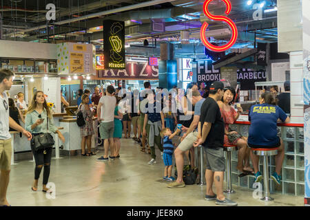 Feinschmecker drängen und den neu eröffneten Dekalb Market Hall befindet sich in Downtown Brooklyn in New York auf Sonntag, 18. Juni 2017 anstehen. Befindet sich im Untergeschoss des City Point Gebäude der 20.000 Quadratfuß Food Hall beherbergt 40 Anbietern von ethnischen Leckereien bis hin zu den ersten jemals Vorposten des Katzs Delicatessen. Keine Kette Restaurant in Sicht bietet die Food Hall alle lokale Anbietern. (© Richard B. Levine) Stockfoto