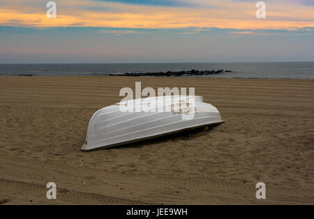 Ein einsames Leben Boot am Strand früh im goldenen Licht des Morgens Stockfoto