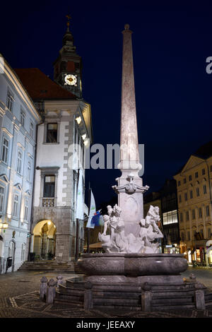 Beleuchteten Robba Brunnen der drei Flüsse in der Square von Ljubljana Hauptstadt von Slowenien in der Dämmerung mit Glockenturm des Rathauses Stockfoto