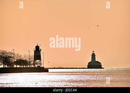 Frühe haze bleibt in den Himmel nach Sonnenaufgang eine Silhouette des Chicago Hafen Leuchtturm und einen Kanal Marker zur Verfügung zu stellen. Chicago, Illinois, USA. Stockfoto