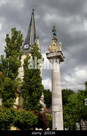 Uhr und Glocke Turm von St. James Parish katholische Kirche und St. Marien Spalte der Jungfrau in Messing und steinernen Statuen der Heiligen Ljubljana Slowenien Stockfoto