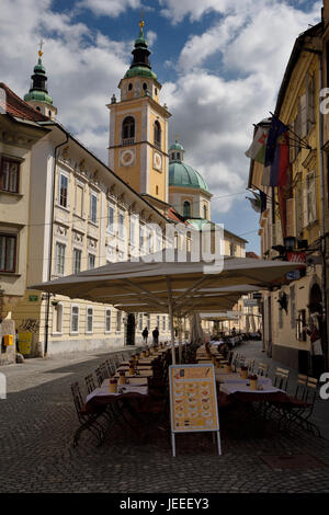 Leere Tische für Touristen auf der Straße bei Cyril Methodius Quadrat mit St. Nikolaus Kirche Ljubljana Kathedrale in Ljubljana Slowenien Stockfoto