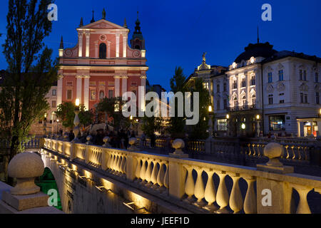 Lichter auf rosa Fassade der Franziskaner Kirche der Verkündigung und Central Apotheke Preseren Square in der Abenddämmerung auf Triple Bridge Ljubljana Slowenien Stockfoto