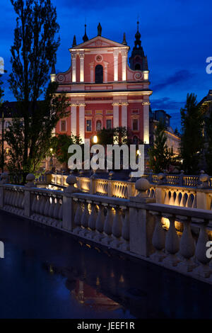 Rosa Fassade des Franziskaner-Kirche der Mariä Verkündigung in der Abenddämmerung mit Beton Balustraden Triple Bridge entworfen von Joze Plecnik Ljubljana Slowenien Stockfoto