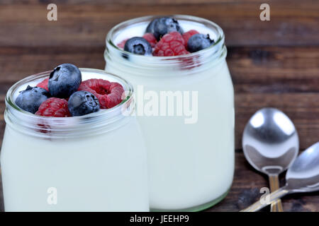 Gläser mit Joghurt und verschiedene Beeren auf Tabelle Nahaufnahme Stockfoto