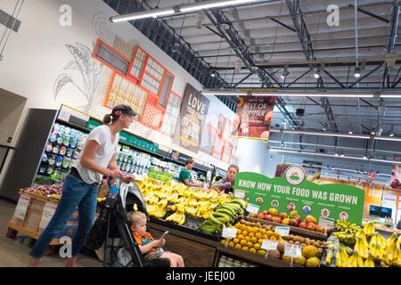 Eine weibliche Shopper schiebt ihr Kind im Kinderwagen durch die Gemüseabteilung im Supermarkt Whole Foods Market in Dublin, Kalifornien, 16. Juni 2017. Stockfoto