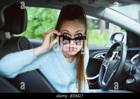 schockiert junge hübsche Frau im Auto Stockfoto