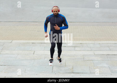 Junger Mann Joggen im städtischen Umfeld Stockfoto