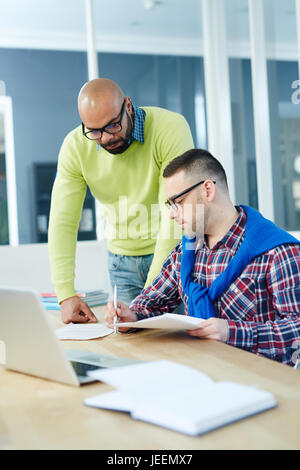 Zwei Spezialisten lesen finanziellen Papiere im Büro Stockfoto