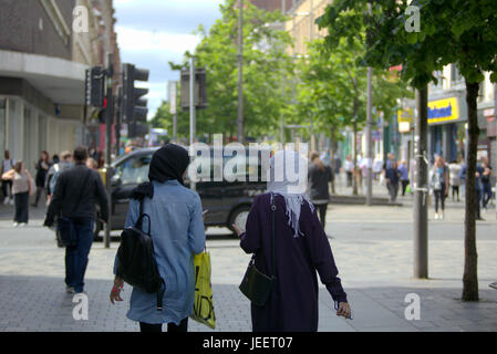 Asiatische Familie Flüchtling gekleidet Hijab Schal auf Straße in der UK alltägliche Szene zwei junge Mädchen einkaufen Stockfoto