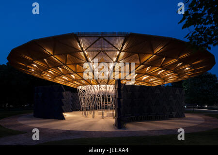 Zeigen Sie Nachtzeit mit beleuchteten Pavillon an. Serpentin Sommer Pavillon 2017, London, Vereinigtes Königreich. Architekt: Diebedo Francis Kéré, 2017. Stockfoto