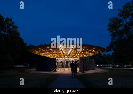 Zeigen Sie Nachtzeit mit Menschen in der Silhouette an. Serpentin Sommer Pavillon 2017, London, Vereinigtes Königreich. Architekt: Diebedo Francis Kéré, 2017. Stockfoto