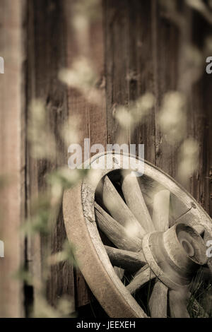 Altes Wagenrad ländliche Gebäude Außenwand. Rustikale Holz Nostalgie-Objekt. Stockfoto