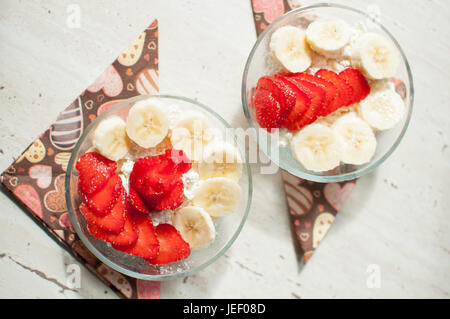 Zwei Schüsseln mit Quark mit Erdbeeren und Bananen. Nahaufnahme, selektiven Fokus. Stockfoto