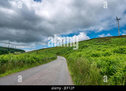 Remote leer Single Track Road in der schottischen Landschaft der Windenergieanlagen auf einem Hügel führt, Scottish Borders, Schottland, Großbritannien Stockfoto