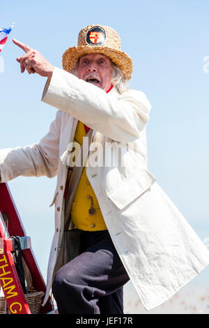 Herr William Thompkins, Anzünder, Charles Dickens Charakter, Geschichte. Das Tragen von weißen Mantel und Strohhut, steht auf Ladder gegen Licht mit Union Jack. Stockfoto