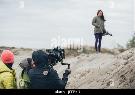 Hinter den Kulissen. Schauspielerin vor der Kamera auf dem Film set Outdoor-Location. Gruppe-Filmszene Stockfoto