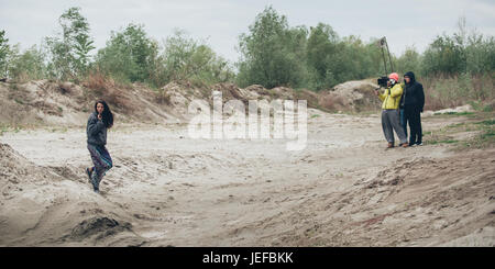 Hinter den Kulissen. Schauspielerin vor der Kamera auf dem Film set Outdoor-Location. Gruppe-Filmszene Stockfoto