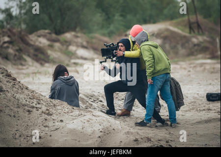 Hinter den Kulissen. Schauspielerin vor der Kamera auf dem Film set Outdoor-Location. Gruppe-Filmszene Stockfoto
