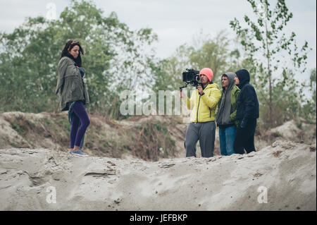 Hinter den Kulissen. Schauspielerin vor der Kamera auf dem Film set Outdoor-Location. Gruppe-Filmszene Stockfoto