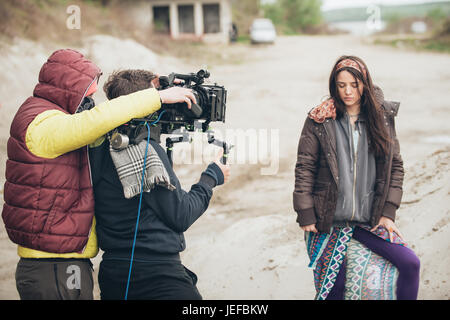 Hinter den Kulissen. Schauspielerin vor der Kamera auf dem Film set Outdoor-Location. Gruppe-Filmszene Stockfoto