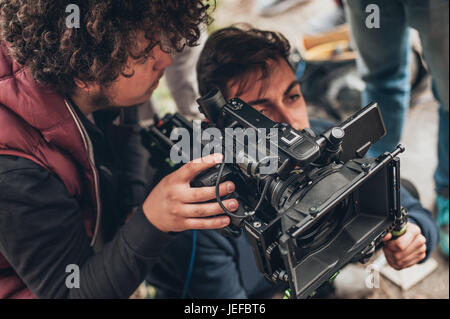 Hinter den Kulissen. Kameramann und Assistent die Filmszene mit Kamera auf Outdoor-Location shooting Stockfoto