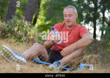 reifer Mann Trinkwasser außerhalb Stockfoto
