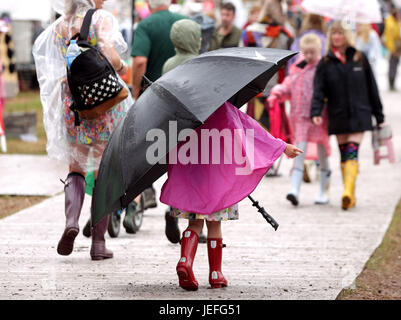 Eine junge Besucherin Unterstände unter einem Regenschirm am Glastonbury Festival in würdiger Farm in Somerset. PRESSEVERBAND Foto. Bild Datum: Samstag, 24. Juni 2017. Finden Sie unter PA Geschichte SHOWBIZ Glastonbury. Bildnachweis sollte lauten: Yui Mok/PA WireA jungen Festival Goer tragen ein Riesenschirm im Regen auf dem Glastonbury Festival würdig Farm in Pilton, Somerset. PRESSEVERBAND Foto. Bild Datum: Samstag, 24. Juni 2017. Finden Sie unter PA Geschichte SHOWBIZ Glastonbury. Bildnachweis sollte lauten: Yui Mok/PA Wire Stockfoto