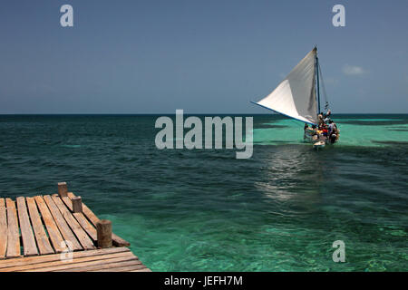 Hölzerne Pier und Segeln Schiff, Tobacco Caye, Belize Stockfoto