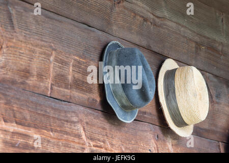 zwei Mützen in einer Holzwand hängen Stockfoto