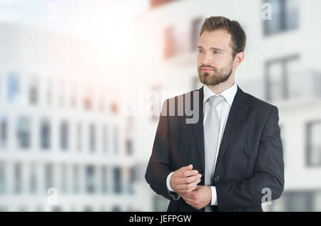 Junger Geschäftsmann im Anzug mit Stadt im Hintergrund. Geschäftsmann Wohnung schöner City Stil Menschen kaukasischen glücklich-Konzept Stockfoto