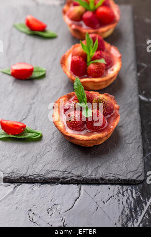 Hausgemachte Erdbeeren Kuchen auf Schiefer Platte, schwarzer Hintergrund. Stockfoto