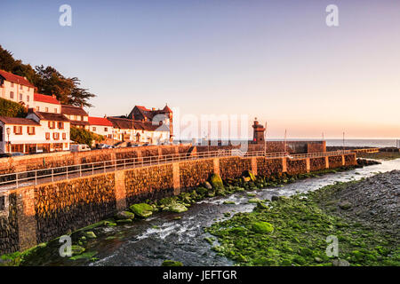 Der Fluss Lyn übergibt der Hafenmauer auf seinem Weg zum Meer bei Lynmouth, Devon, England, UK. Gesehen bei Sonnenaufgang an einem klaren Sommermorgen. Stockfoto