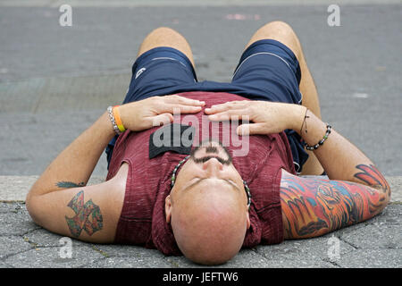 Foto eines ruhenden Menschen mit Tattoos trug eine Tank-Top aus einem ungewöhnlichen Blickwinkel fotografiert. Stockfoto