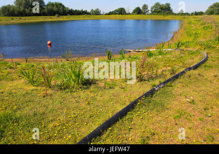 Wasserleitung aus der landwirtschaftlichen Bewässerung See, Sutton, Suffolk, England, Großbritannien Stockfoto