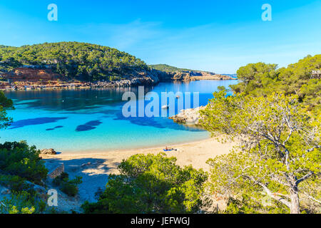 Paar Unidentifed Leute Sonnenbaden am schönen Strand von Cala Salada berühmt für seine Azure kristallklares Meerwasser, Insel Ibiza, Spanien Stockfoto