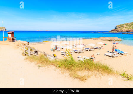 CALA COMTE BAY, Insel IBIZA - 17. Mai 2017: Sonnenliegen und Sonnenschirme am Strand der Cala Comte viele Touristen im Urlaub, Insel Ibiza, Spanien entspannen. Stockfoto