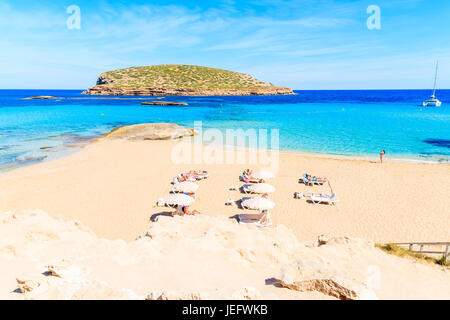 CALA COMTE BAY, Insel IBIZA - 17. Mai 2017: Sonnenliegen und Sonnenschirme am Strand der Cala Comte viele Touristen im Urlaub, Insel Ibiza, Spanien entspannen. Stockfoto