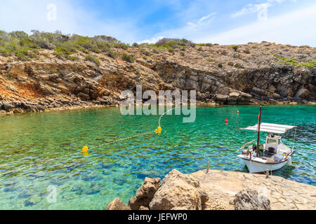 Weiße typischen Fischerboot ankern in wunderschönen Cala Carbo Bucht mit smaragdgrünes Meerwasser, Insel Ibiza, Spanien Stockfoto