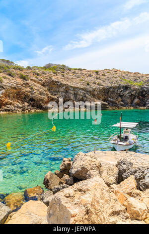 Weiße typischen Fischerboot ankern in wunderschönen Cala Carbo Bucht mit smaragdgrünes Meerwasser, Insel Ibiza, Spanien Stockfoto