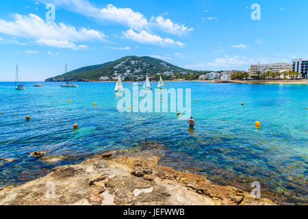 Unbekannter Mann stehend im Wasser am Strand von Santa Eularia, Insel Ibiza, Spanien Stockfoto