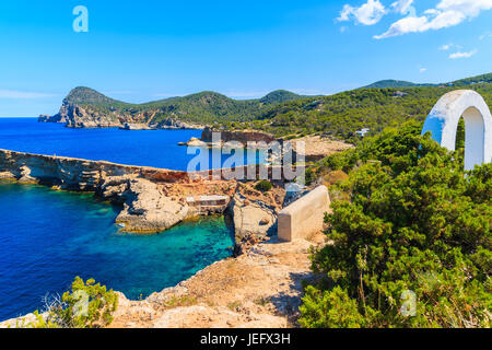 Weißer Bogen Tor auf Küstenpfad nach Punta Galera Bucht umgeben von erstaunliche Steinformationen, Insel Ibiza, Spanien Stockfoto