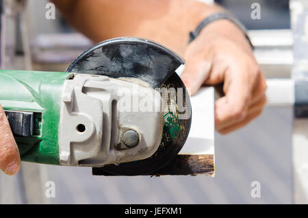 Nahaufnahme eines Mannes mit elektrischen Vorrichtung aus Holz Schneidebrett Stockfoto