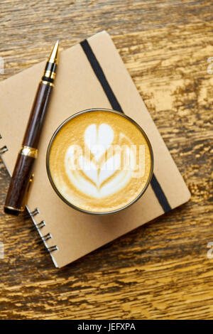 Kaffee, Stift und Notizbuch. Stockfoto