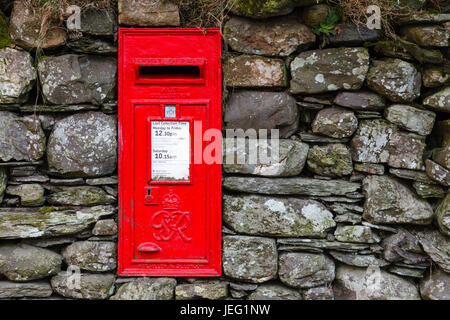 Ein traditionelle rote englische Briefkasten montiert in einer Trockensteinmauer im Dorf Buttermere im englischen Lake District National Park. Stockfoto