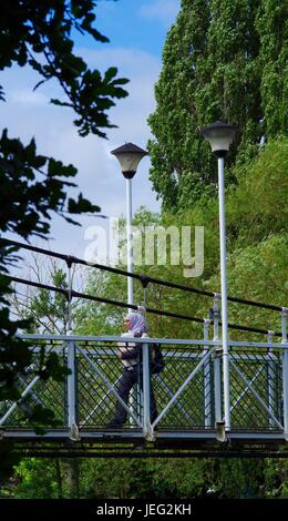 Muslimische Frau Karottenhosenträger Weir Hängebrücke überqueren. Kai Exeter, Devon, UK. Juni 2017. Stockfoto