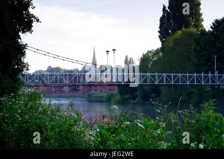 Karottenhosenträger Wehr Hängebrücke über den Fluss Exe und der Turm der Kirche St. Leonard im Morgengrauen. Exeter, Devon, UK. Juni 2017. Stockfoto