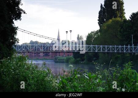 Karottenhosenträger Wehr Hängebrücke über den Fluss Exe und der Turm der Kirche St. Leonard im Morgengrauen. Exeter, Devon, UK. Juni 2017. Stockfoto